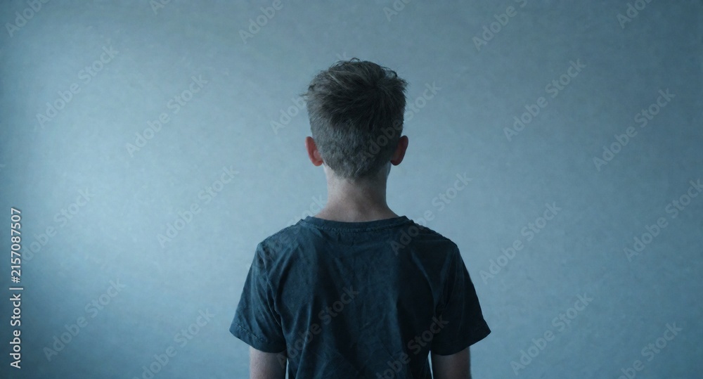 Obraz premium Young Man Back View Against Minimalist Blue Background Studio Portrait