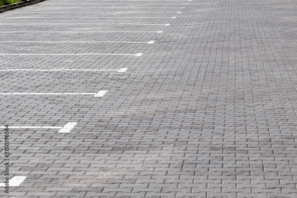 Fototapeta premium Empty parking lot with many spaces and some grass areas
