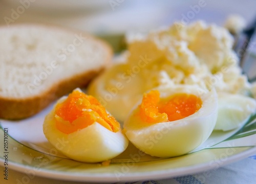 soft-boiled egg with a bright orange yolk on a healthy breakfast plate