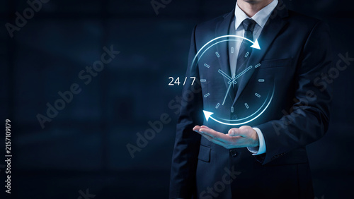 Business professional holding a glowing holographic clock icon representing twenty four seven support and customer service