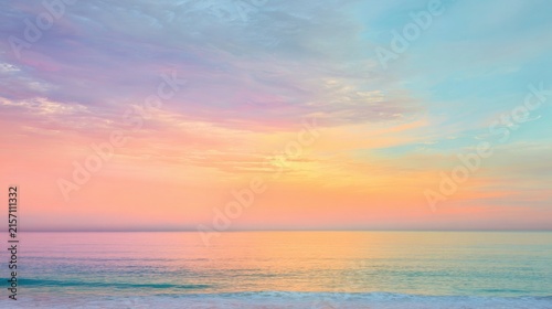 Soft pastel sunrise over calm ocean horizon with waves with pastel dawn sky