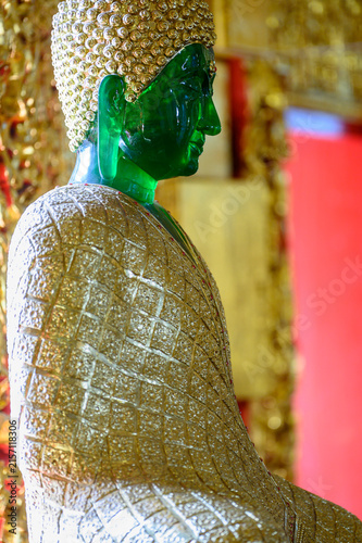 Emerald Green Buddha Statue with Ornate Golden Robe in Thai Temple