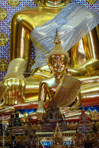 Small Golden Buddha Statue in Front of Large Buddha Image at Thai Temple