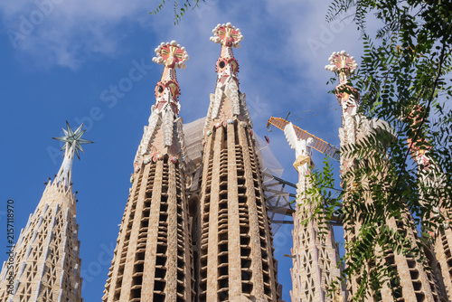 View of the monumental towers and decorative architecture of the Sagrada Familia in Barcelona, a world famous tourist attraction and architectural landmark designed by Antoni Gaudi.