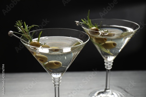 Bild auf Leinwand Martini cocktails with olives and rosemary in glasses on table, closeup