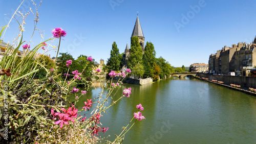 Fotografie Pink flowers framing Metz city view with Temple Neuf and Moselle River on a sunn