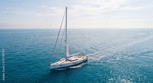 Sailing yacht on ocean, white sailboat cruising on blue sea water under bright sunny sky, aerial view of luxury sailing vessel, nautical travel and summer vacation sports.