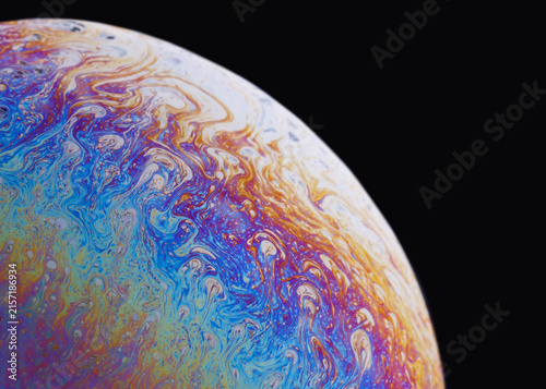 Foto Macro abstract showing delicate film textures and flowing marble-like color striations reminiscent of a tiny planet