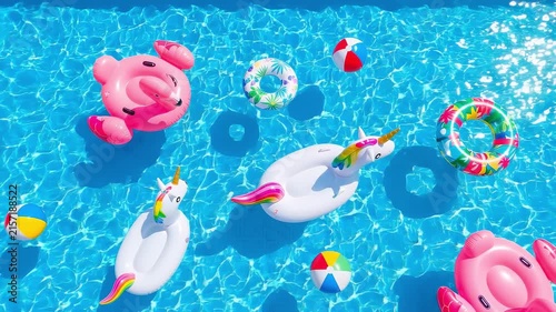 Colorful inflatable flamingo and unicorn pool floats drifting in bright blue swimming pool water