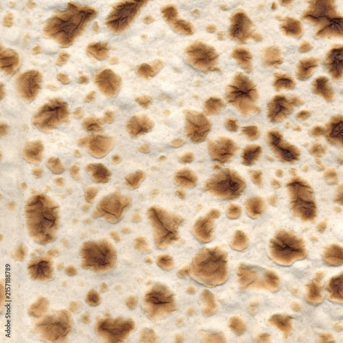 Close-up texture of unleavened matzo flatbread: ideal for Passover (Pesach) holiday menus, Jewish food recipes, and cultural blog backgrounds