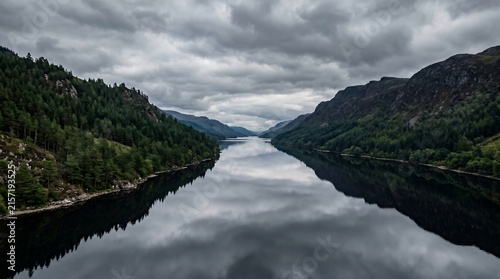 Loch Ness Scotland calm pewter water with brooding pine-forested hills and cloud, Ultra High-Definition Background Stock Image.