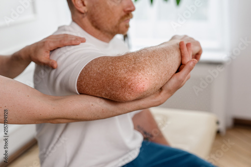 Physiotherapist examines patient joint during therapy in hospital setting
