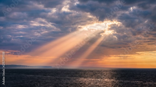 Crepuscular rays god rays through clouds over English Channel at evening, High-Resolution Travel and Nature Stock Photo.