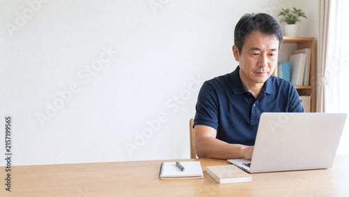 自宅でパソコンに向かう日本人シニア男性 オンライン学習と余白