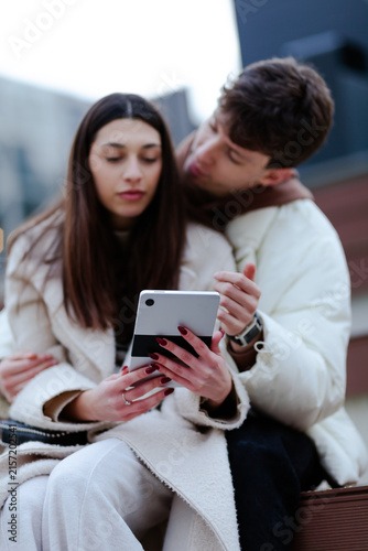Obraz na płótnie Romantic couple using a digital tablet outdoors in a contemporary urban setting