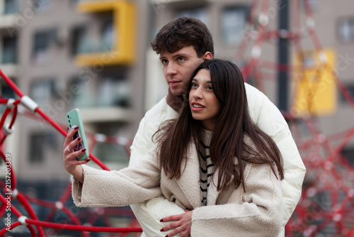 Foto Couple Outdoors Taking a Selfie Together Amid Colorful Urban Structure