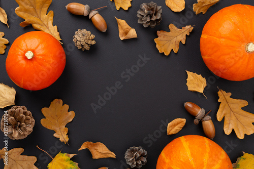 Autumn leaves with pumpkins on color background, top view