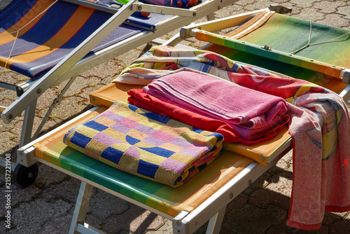 Fotografía Colorful Beach Towels Folded on Sun Loungers in Bright Summer Sunlight