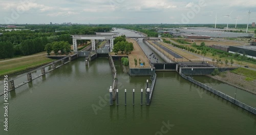 Drone horizontally tracks leisure boats and a tanker barge waiting inside a sluice chamber for the gate to open, allowing vessels to continue their journey along the river.