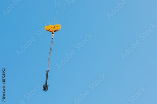 Konstfotografi Suspended Crane Hook and Rigging Against Clear Blue Sky