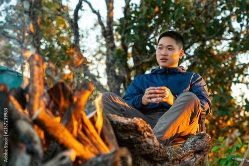 Bild auf Leinwand Asian man drinking hot coffee while solo travel nature and camping at forest mountain