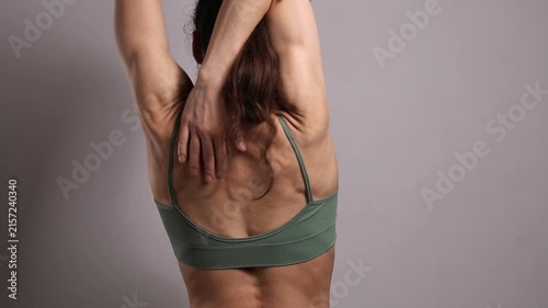Fit woman performing shoulder and upper back stretches, improving flexibility, mobility, posture and muscle recovery during a fitness and wellness workout in a studio.