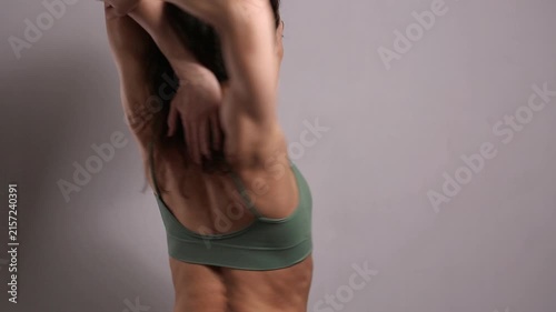 Fit woman performing shoulder and upper back stretches, improving flexibility, mobility, posture and muscle recovery during a fitness and wellness workout in a studio.