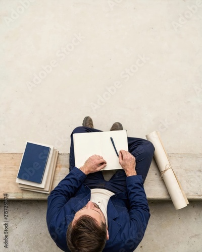 Man Writing Notes in Notebook Overhead View for Planning