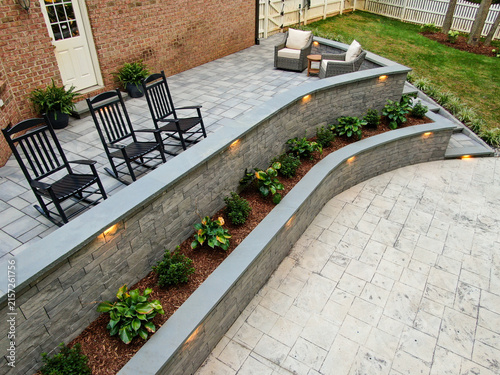 Konstfotografi Elevated Angle Of Curved Stone Retaining Wall With Integrated Lighting And Patio