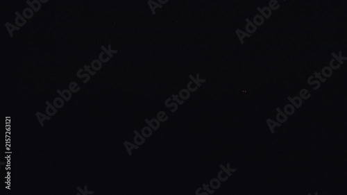 The glowing red‑and‑white trails of tracer bullets from an anti‑aircraft machine gun in the dark night sky. High quality 4k footage