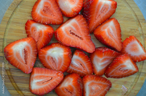 Freshly sliced strawberries on wooden cutting board