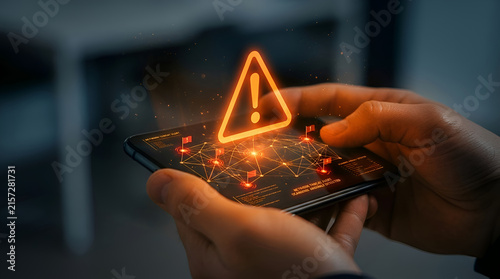Hand holding microchip with glowing orange warning triangle symbolizing cybersecurity threat detection