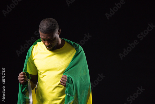 Картината върху платно Mid-adult African man posing in studio, wearing yellow tee, holding green-yellow