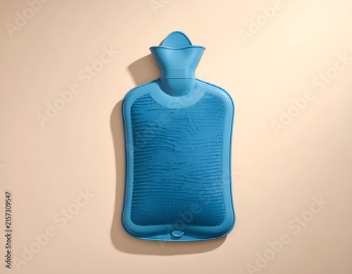 Blue rubber hot water bottle on beige surface.