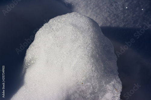 Obraz na plátně Shimmering ice crust formed on deep winter snowdrift under bright sunlight, high