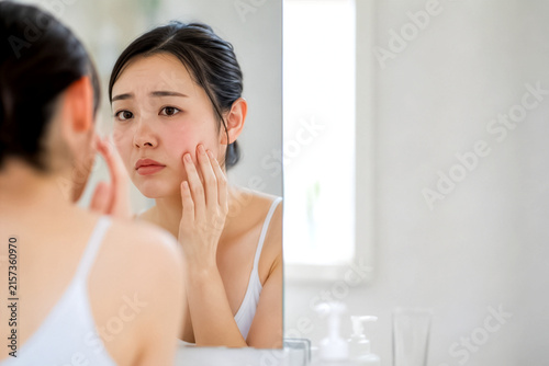 Obraz w ramie 鏡の前で肌チェックをする女性