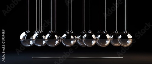 Close up row of hanging glass pendulum balls.
