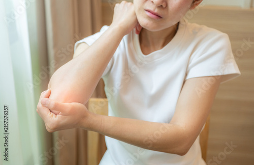 Obraz na plátně Cropped shot view of Asian woman holding and massaging her elbow because of pain