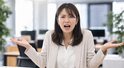 理不尽な問題やお手上げの状況に困惑しお手あげポーズをする会社員の女性