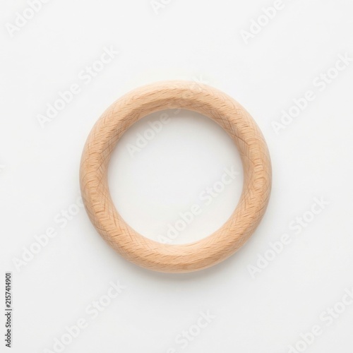 Natural wooden baby teether ring on white background