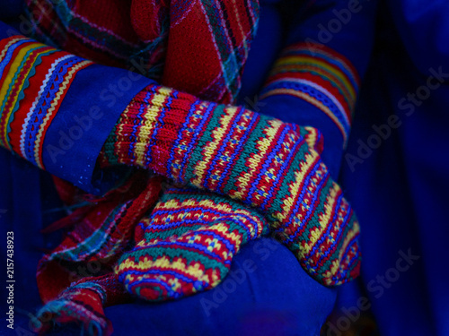 Close-up of colorful hand-knitted Sámi mittens featuring traditional geometric patterns in red, blue, green and yellow.