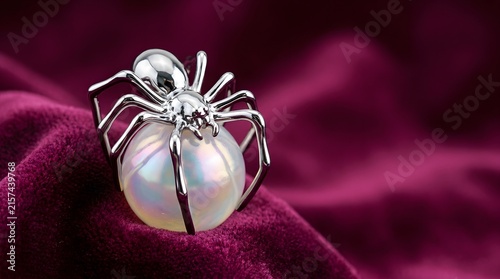 A captivating and slightly eerie image showcases a highly detailed iridescent spider poised against a swirling dramatic and vividly colored magenta background creating a