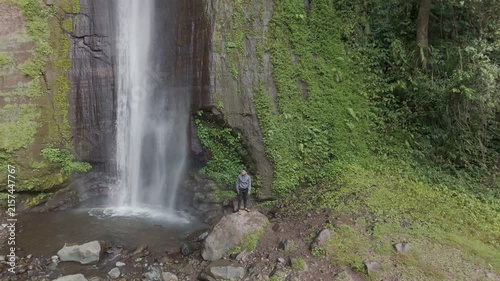 A Serene Moment by a Majestic Waterfall Surrounded by Lush Greenery and Tranquil Nature