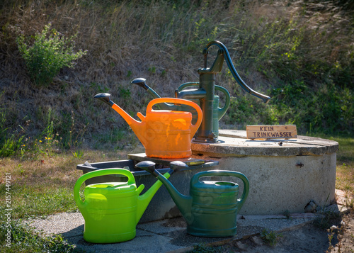 Fotografía Old hand water pump on meadow in countryside – sustainable water concept