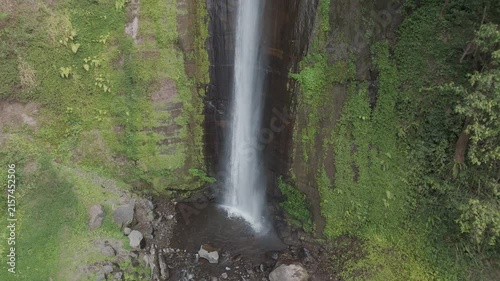 Stunning Aerial View of a Majestic Waterfall Surrounded by Lush Greenery and Rocks in Tranquil Nature