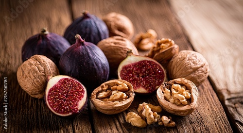 Ripe figs and walnuts arranged on a rustic wooden surface