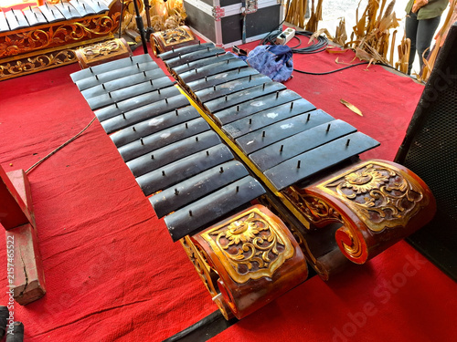Traditional javanese saron gamelan musical instruments with carved wooden bases on red carpet.