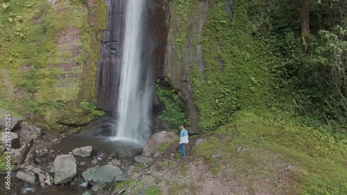 A Tranquil Waterfall Surrounded by Lush Green Foliage and Rocky Outcrops at Dusk