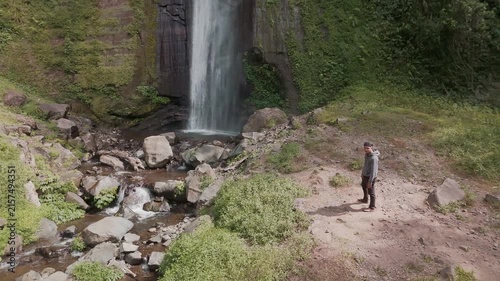 A Serene Exploration of Nature's Beauty at a Majestic Waterfall Surrounded by Lush Greenery