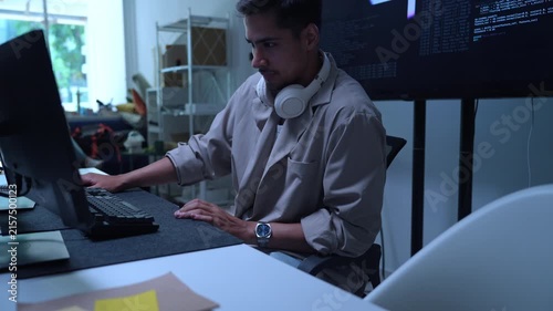 AI developers and technology professionals work at modern office computers, writing software code and analyzing data for artificial intelligence projects.